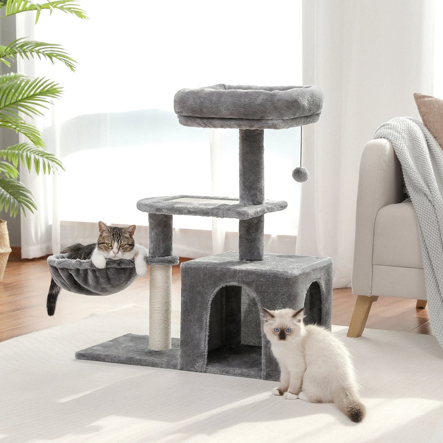 cat stand with hammock, grey plush material with rope on the post, hanging ball from bottom of top tier which is a soft sided bed, second tier is flat covered with the plush material, the hammock sits just below the second tier, the bottom tier has a covered condo for the cat to hide